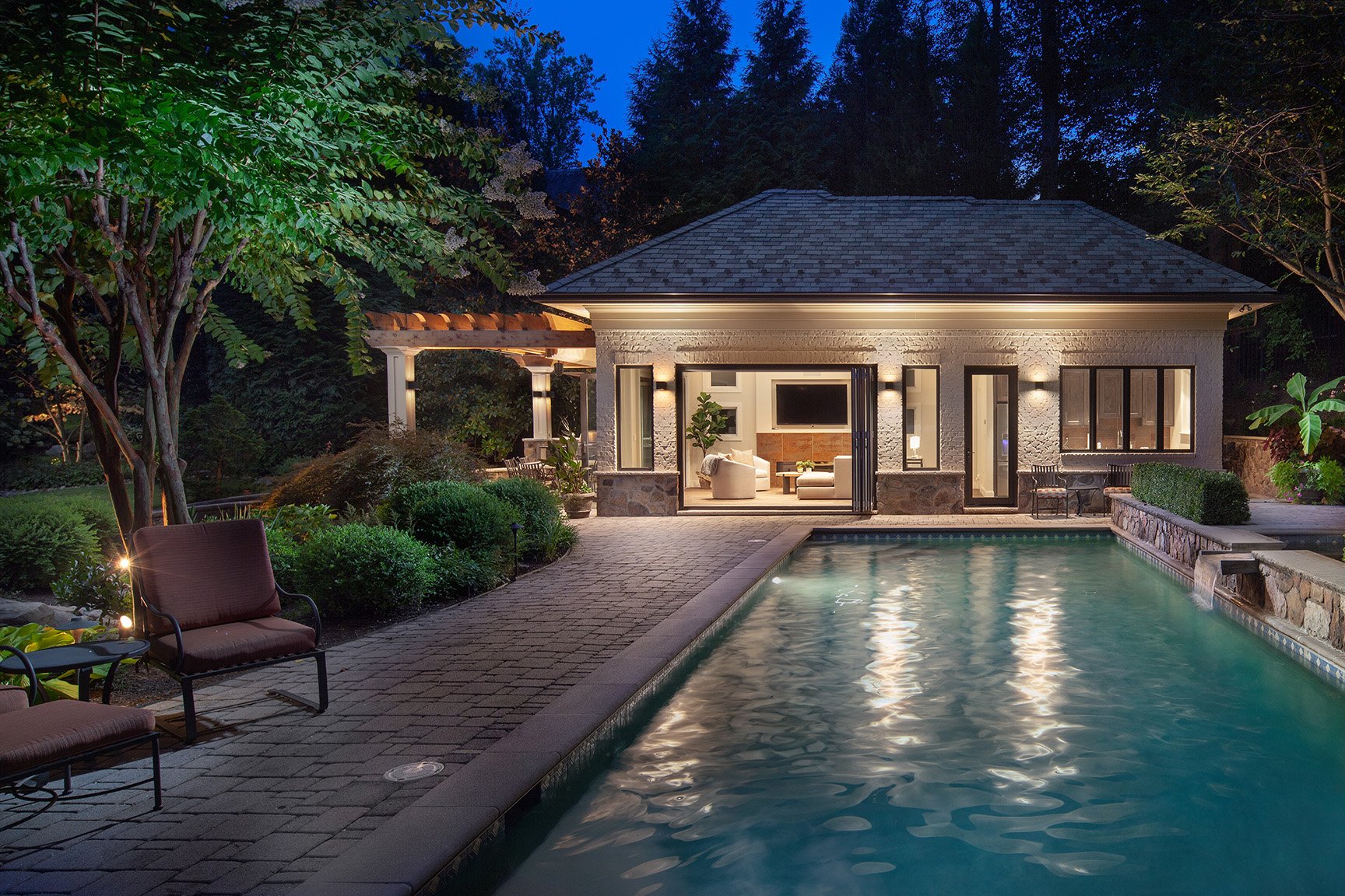 A beautiful outdoor pool and pool house build and designed by Rossen Landscapes